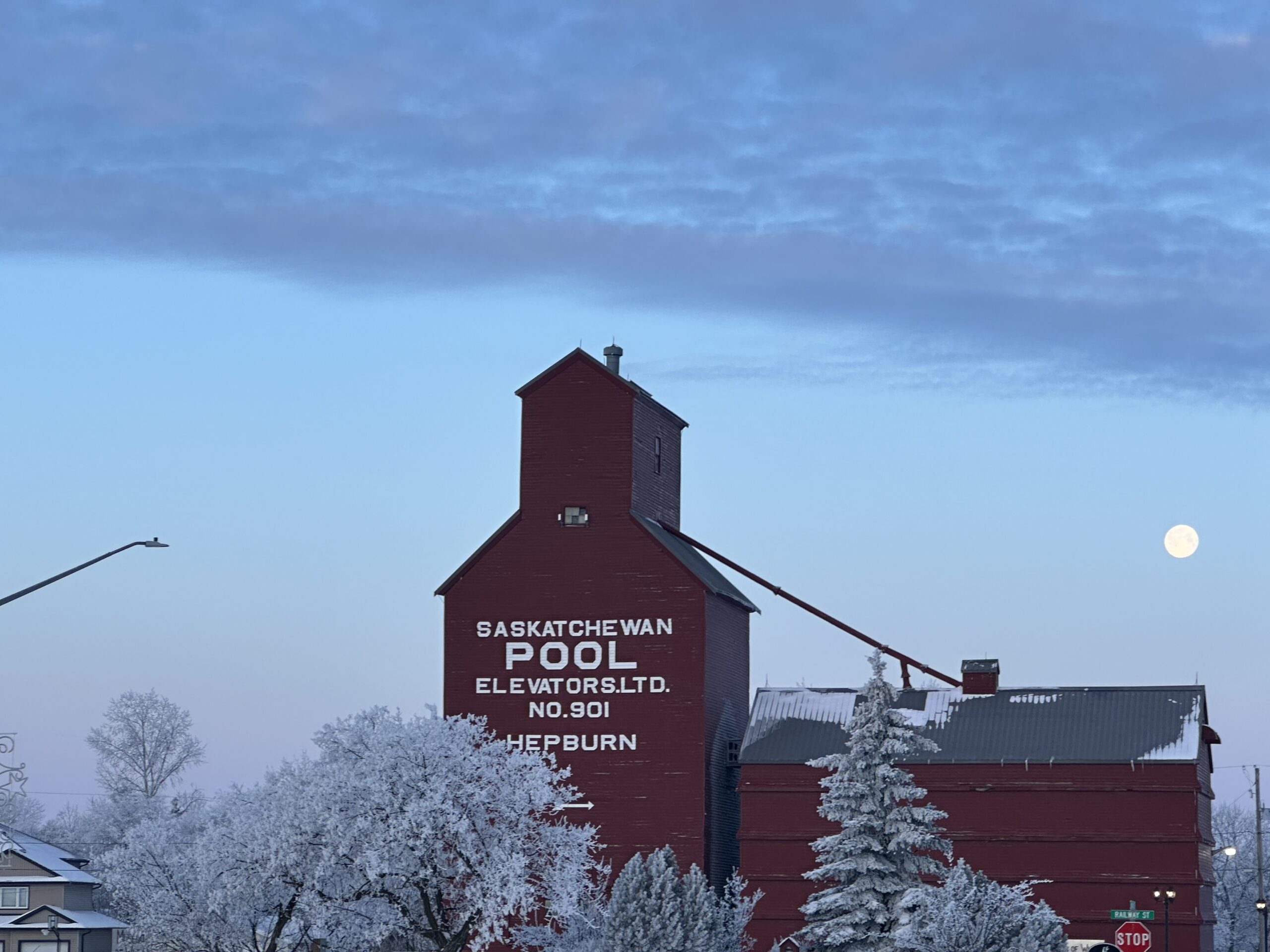 A prairie grain elevator against a clear blue sky